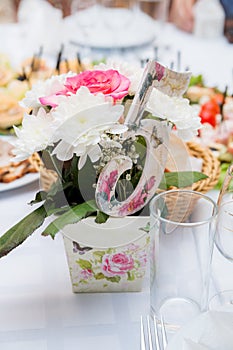 Wedding. Banquet. Flowers. The composition of red, white and green, standing on a table in the area of wedding party.