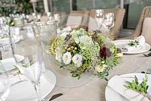 Wedding Banquet or gala dinner. The chairs and table for guests, served with cutlery and crockery. Covered with a linen