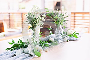 Wedding. Banquet. Table for guests, covered with a tablecloth, decorated with candles, transparent glass vases, fresh flowers