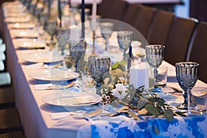 Wedding banquet. Table setting with blue glasses.