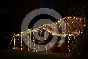 wedding banquet tent at night lit with fairy lights