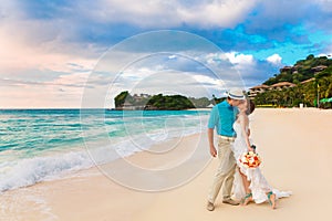 Wedding. Bbride and groom kissing on the tropical coast at sunset