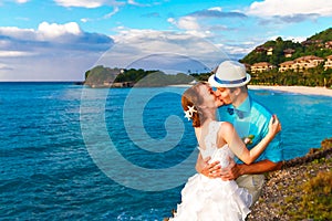 Wedding. Bbride and groom kissing on the tropical coast at sunset