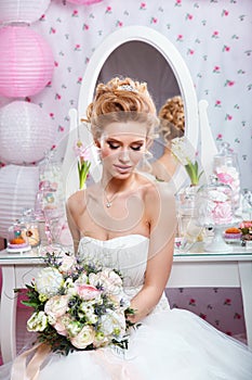 Wedding. Beautiful bride with bouquet in bedroom