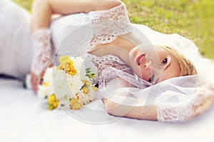 Wedding, beautiful bride lying on the ground