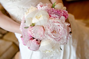 Wedding beautiful pink piwon bouquet in bride hands some blur background