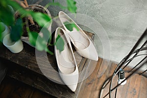 Wedding beige women shoes on wooden floor. Vintage toning image.