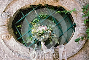 Wedding bouquet on a barred window in the garden