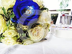 Wedding bouquet with blue and white roses resting on the table