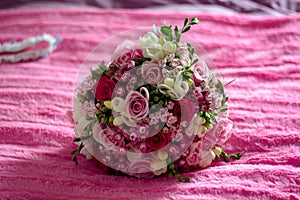Wedding bouquet for bride on the bed photo