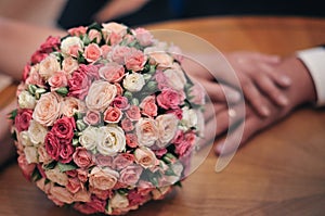 Wedding bouquet of bride with hands on background