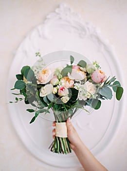 Wedding bouquet. Bride holds tender peony bouquet with white and rosy flowers, beautiful wedding concept.