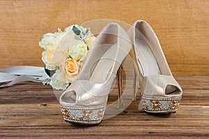 Wedding bouquet with bride's shoes on wood background