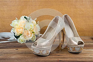 Wedding bouquet with bride's shoes on wood background