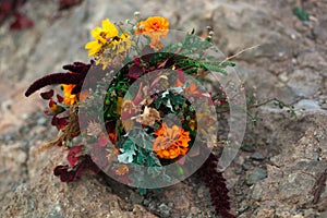 Wedding bouquet in a bright autumn style. On the background of stone rocks. Marigold flowers