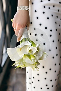 Wedding bouquet of callas in the hands of the bride close-up