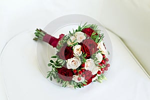 Wedding bouquet of carnations and roses, on a white chair