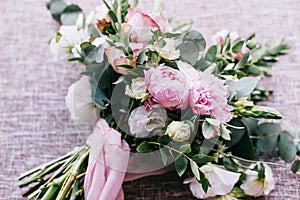 The wedding bouquet of fiancee of tender tints lies on fabric from flax