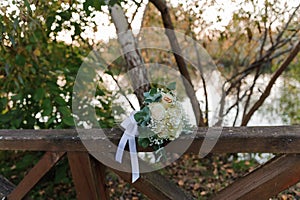 Wedding bouquet of fresh flowers, a pair of gold rings close-up. Wedding details