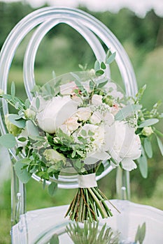 Wedding bouquet on the glass chair, outdoor, fine art.