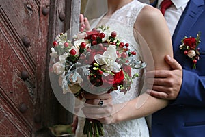 Wedding bouquet in hands of bride against the background of vint