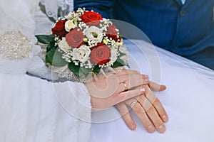 Wedding bouquet in hands of the bride and groom photo