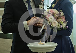 Wedding bouquet in hands of bride and groom, selective focus