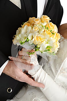 Wedding bouquet in hands of bride and groom, on wh