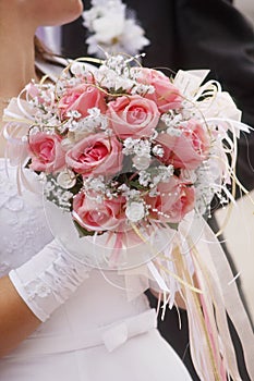 Wedding bouquet in hands of the bride in a white dress photo