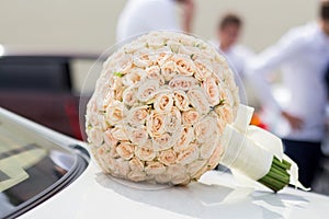 Wedding bouquet on the hood of the car