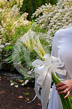 Wedding bouquet with kala flowers bride& x27;s hand outdoors