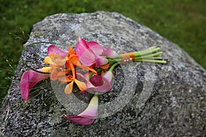 Wedding bouquet laying on a large rock