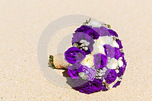 Wedding bouquet lying on the sand on a tropical beach.