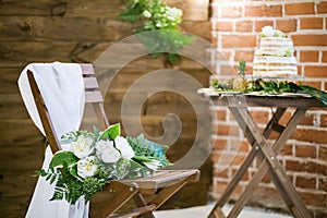 Wedding bouquet lying on wooden chair for wedding ceremony
