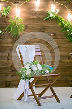 Wedding bouquet lying on wooden chair for wedding ceremony