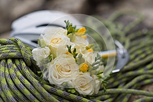 A wedding bouquet made of white roses on a rope with an ice ax