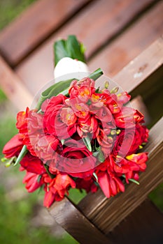 Wedding bouquet of mixed red roses on a bench