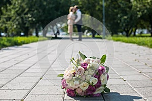 Wedding bouquet and the newlyweds in the park a beautiful wedding