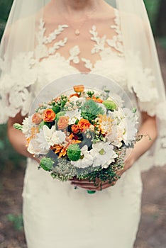 Wedding bouquet of orange roses, white and orange chrysanthemums.