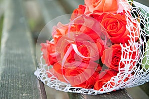 Wedding bouquet of red roses lies on the bench. Fragrant flowers, smell beautiful