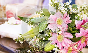 Wedding bouquet and ring pillow in background