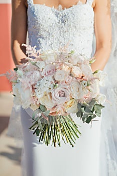 Wedding bouquet with roses in the hands of the bride