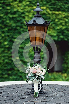 Wedding bouquet in a stone circle under vintage street lamp