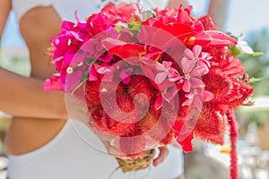Wedding bouquet from tropical flowers in bride's hans on n