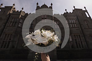 Wedding bouquet of white callas against the background of the castle.