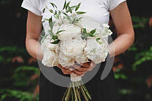 Wedding bouquet of white flowers in boho style.