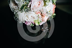 Wedding bouquet of white and pink flowers and wedding rings