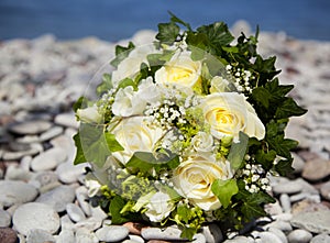 Wedding bouquet with yellow roses laying on a limestone beach