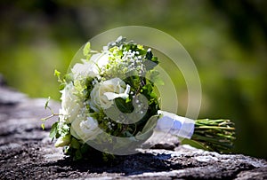 Wedding bouquet with yellow roses laying on a limestone wall