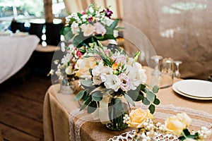 Wedding bouquets of yellow, white and pink roses are in vases